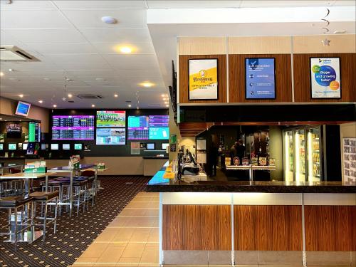 a restaurant with a bar and tables and televisions at Inala Hotel in Brisbane