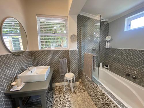 a bathroom with a sink and a shower and a tub at Walmer Cottage - Cute & Pet friendly in Cape Town