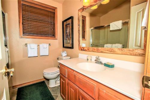 a bathroom with a sink and a toilet and a mirror at Knotty and Nice-177 by Big Bear Vacations in Big Bear Lake