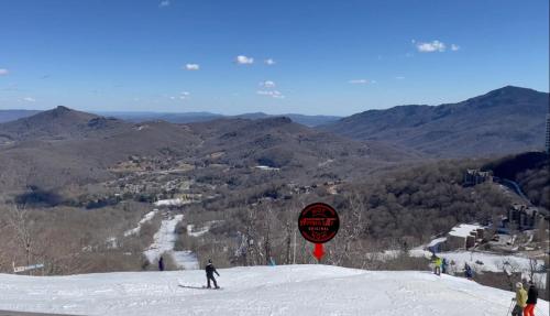 シュガー・マウンテンにあるAPPresSki - 5 bed Ski in Ski out - 50 Steps to Ski Sugar Mountain Slopesの雪山をスキーで下りている人