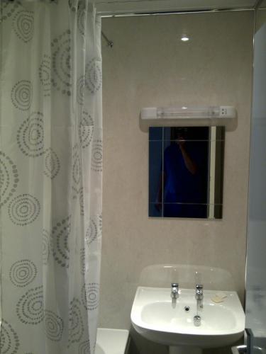 a white bathroom with a sink and a mirror at Lavender Cottage with Parking and Beautiful Views Summer Special in Carsphairn