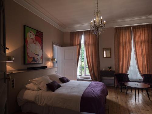 a bedroom with a bed and a table and a chandelier at Une maison en ville, Hyper Centre ville, Spa in Amiens