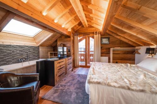 a bedroom with a large bed in a room with wooden ceilings at Chalet Izoard in Saint-Chaffrey