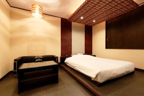 a bedroom with a bed and a desk and a sink at 隠家（ajito）HOTEL555 小田原店 in Kami-soga