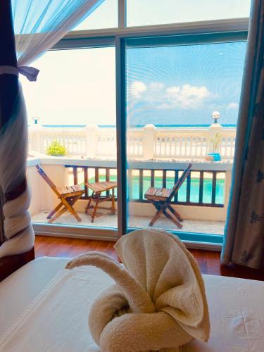 a towel sitting on a bed in front of a window at Mambo Paradise in Matemwe