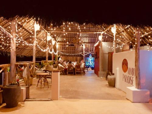 a group of people sitting in a room with lights at Mambo Paradise in Matemwe