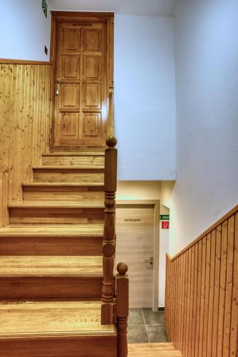 a staircase in a building with a wooden door at MátraForRest in Mátraszentistván