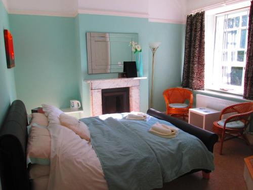 a bedroom with a bed in front of a fireplace at Weston Manor in Freshwater