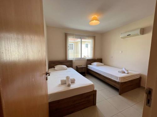 a small room with two beds and a window at Greek Harmony Apartment in Paralimni