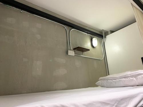 a bed in a room with a metal wall at HappyNest Hostel Cebu in Cebu City