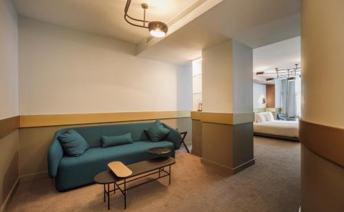 格拉納達的住宿－Hotel Colón Centro，客厅配有蓝色的沙发和床。