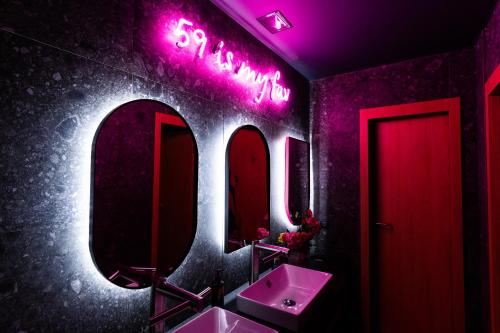 a bathroom with two sinks and a neon sign at Hotel Kitchen59 in Sofia