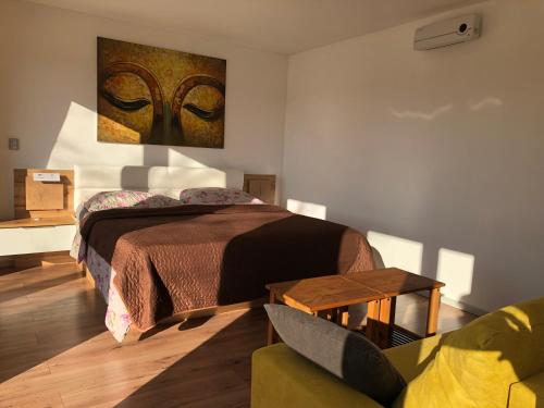 1 dormitorio con cama, mesa y sofá en Apartmán - D - Vyhlídka nad řekou en Zdiby