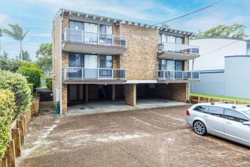 an apartment building with a car parked in the driveway at Coastal Paradise at Fore Dek 3, 17 Soldiers Point Road - water views, linen, Wi-Fi, Air Con in Soldiers Point