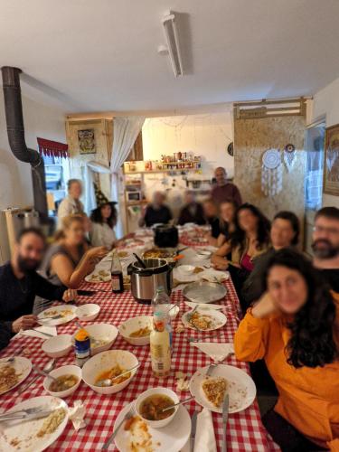 a group of people sitting at a long table eating food at אשראם בכרמל - המקום של אורי in Dāliyat el Karmil
