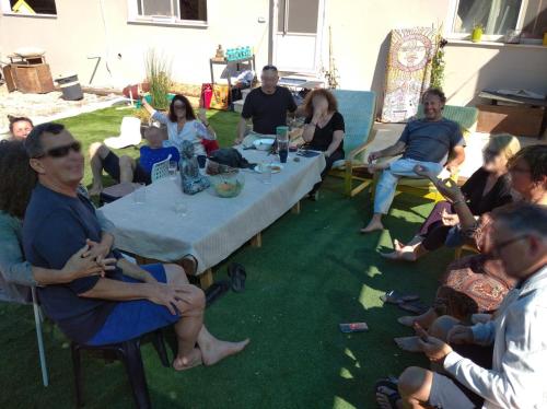 a group of people sitting around a table at אשראם בכרמל - המקום של אורי in Dāliyat el Karmil