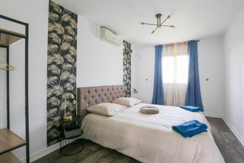 una camera da letto con un grande letto con asciugamani blu di Le Vexin a Gisors