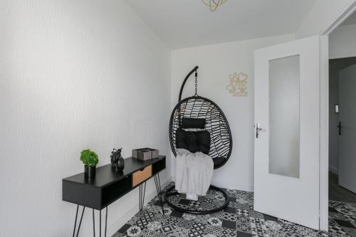a room with a black cat sitting in a chair at Le Vexin in Gisors