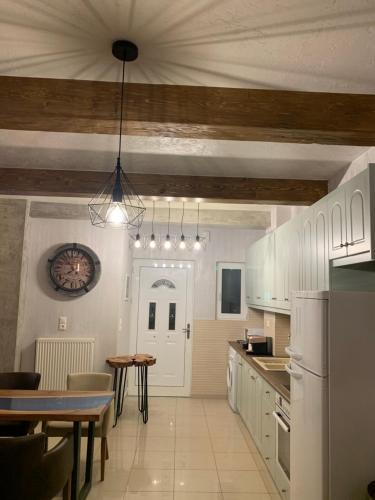 a kitchen with white cabinets and a table in it at modern rustic house in the heart Of the village in Kefalos