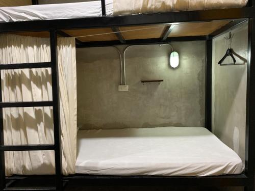 a bunk bed with a white mattress in a room at HappyNest Hostel Cebu in Cebu City