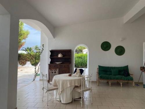 a living room with a table and a green couch at Villa Maria in Villanova di Ostuni