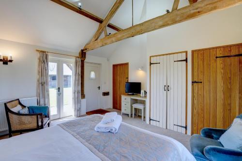 a bedroom with a large white bed and a desk at Red House Farm Accommodation in Tivetshall Saint Margaret