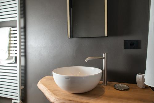 a bathroom with a bowl sink on a wooden counter at Civitaloft Luxury Rooms in Civitanova Marche
