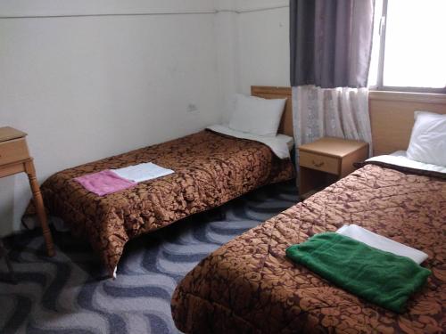 una camera d'albergo con due letti con asciugamani verdi di Queen Ayloa Hotel&Restaurant a Madaba