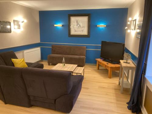 a living room with a couch and a tv at gîte le Dauphin in Saint-Pierre-des-Nids