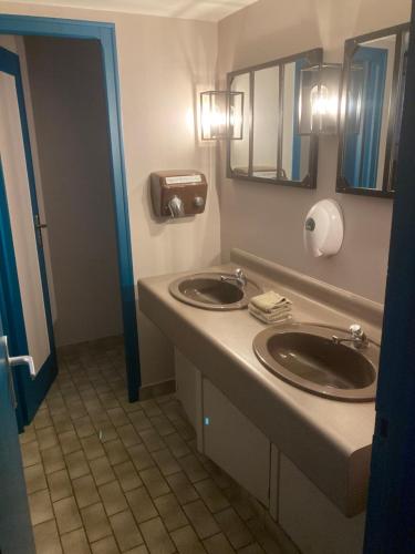 a bathroom with two sinks and two mirrors at gîte le Dauphin in Saint-Pierre-des-Nids