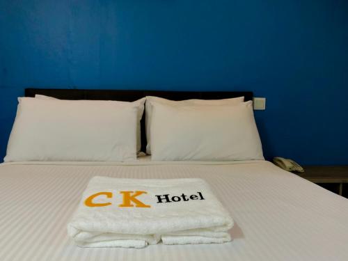 ein Bett mit einem c k Hotel-Handtüchern darauf in der Unterkunft CK Hotel in Malakka