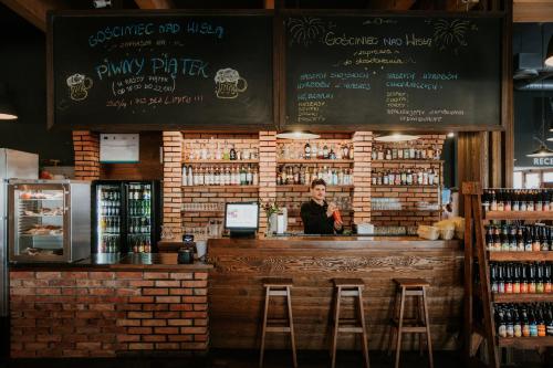 a woman standing behind a bar in a restaurant at Hotel nad Wisłą in Tczew