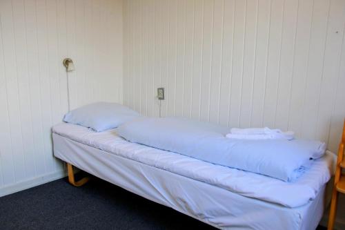 un letto in una camera con due cuscini sopra di The Little Red Cabin Near Blåvand! a Blåvand
