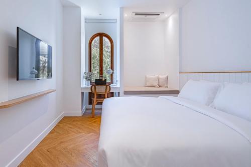 a white bedroom with a bed and a table at Casa 33 Hatyai in Hat Yai