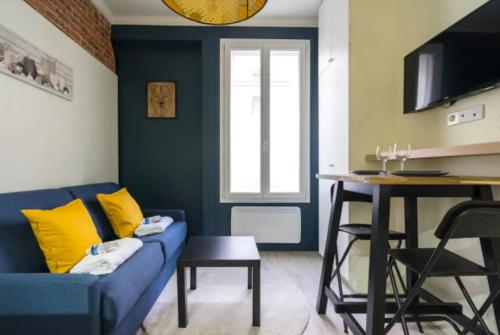 - un salon avec un canapé bleu et une table dans l'établissement CMG Cosy Studio- 2P - Nation - Voltaire, à Paris