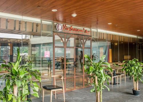 a restaurant with tables and chairs in a building at Bravo Tanauan Hotel in Tanauan