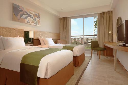 Un pat sau paturi într-o cameră la Diamond Hotel Kuta Bali