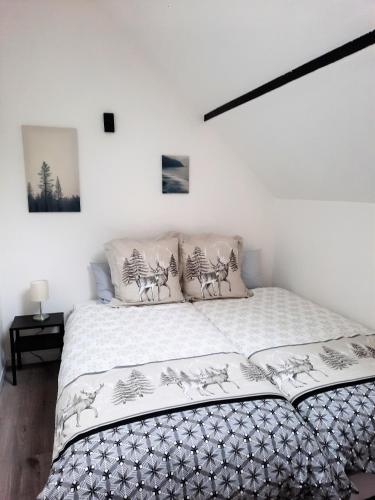 a white bedroom with a bed with white sheets and deer pillows at Gîte L'Equilibre - Lac/montagnes- Familles-groupes in Kruth