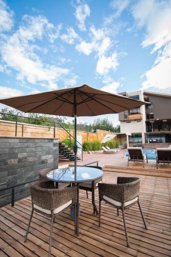 a table and two chairs and an umbrella on a deck at Arhaná Hosteria & Resort in Gualaceo