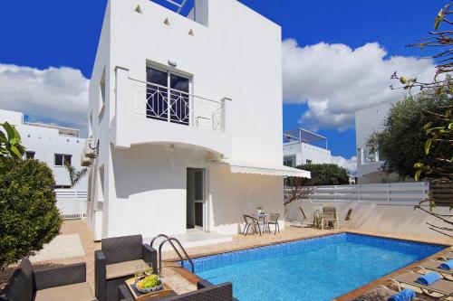 a villa with a swimming pool and a house at Villa Nissinia - Nissi Beach Area in Ayia Napa