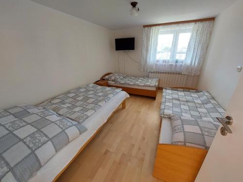 a bedroom with two beds and a window at Kwatera Studio Hoczew in Hoczew