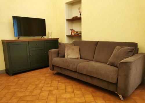 ein braunes Sofa im Wohnzimmer mit einem Flachbild-TV in der Unterkunft Casa del Moro in Florenz