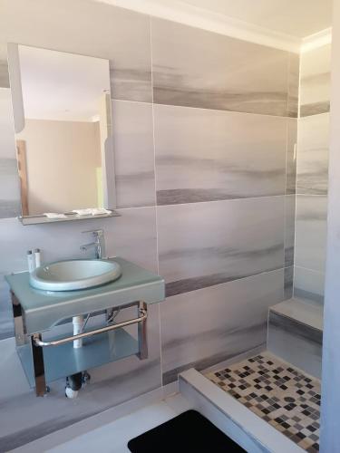 a bathroom with a sink and a mirror at National Lodge in Benoni