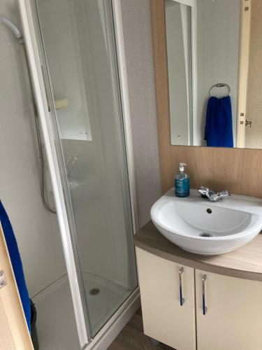 a bathroom with a shower and a sink at Luxury caravan at Turnberry - short walk to beach in Girvan