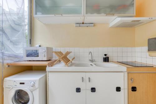 Il comprend une cuisine équipée d'un évier et d'un lave-linge. dans l'établissement Paris 16 Studio cosy Tour Eiffel Auteuil, à Paris