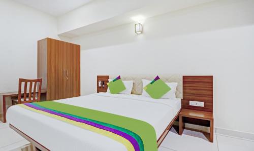 a bedroom with a large bed with a rainbow blanket at Treebo RJ Residency in Mysore