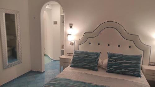 a bedroom with a large bed with two blue pillows at Albergo S. Andrea in Amalfi