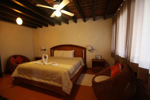 a bedroom with a bed and a ceiling fan at La Capilla Hotel Boutique in Valle de Bravo