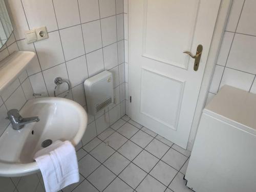 un bagno bianco con lavandino e porta di Am Kurhaus 11b a Nordstrand