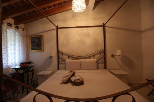 a bedroom with a canopy bed with shoes on it at La Capilla Hotel Boutique in Valle de Bravo